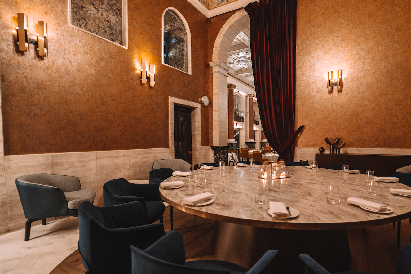 Elegant dining space with round marble table for corporate dinners in Piazza Italiana.