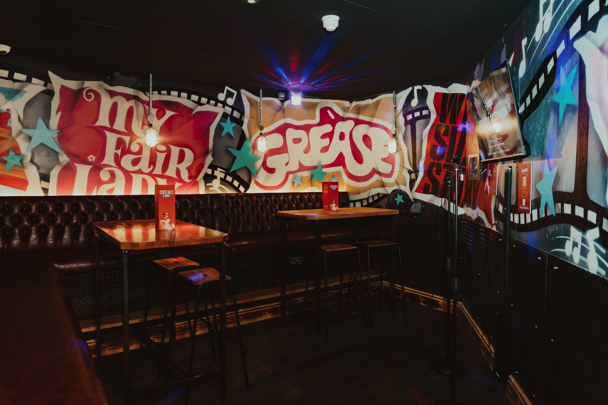 Vibrant karaoke room with graffiti decor, ideal for parties and social gatherings.