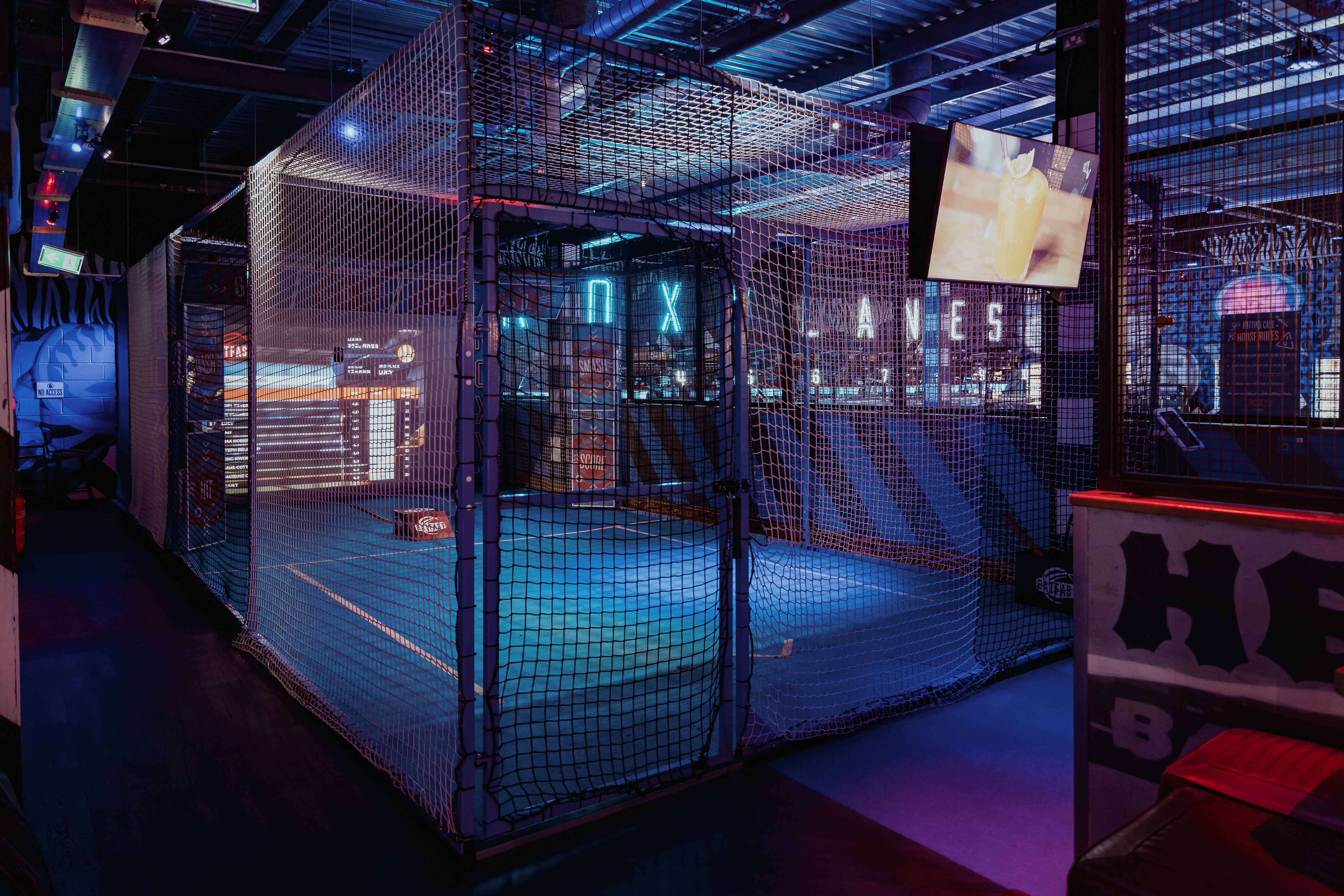 Vibrant Roxy Lanes venue with netted bowling area for corporate events and team-building.