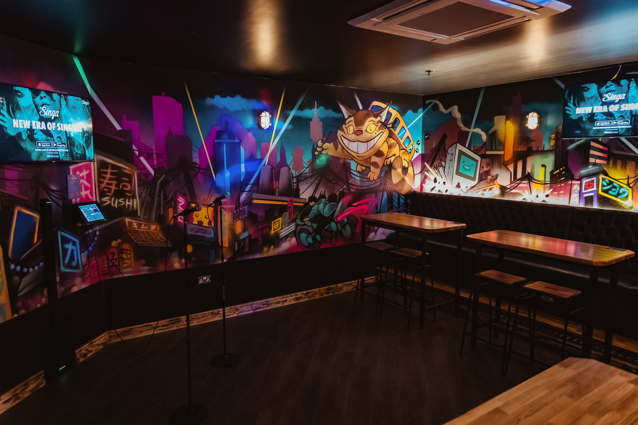 Karaoke room at Roxy Lanes Cardiff with colorful murals, perfect for social events.