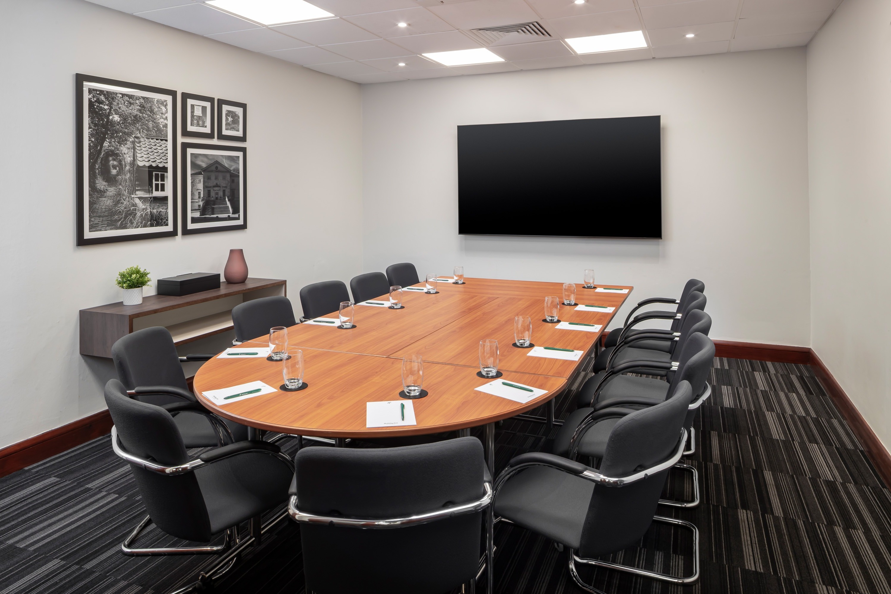 Conference room at Holiday Inn London-Bexley with oval table and ergonomic chairs.