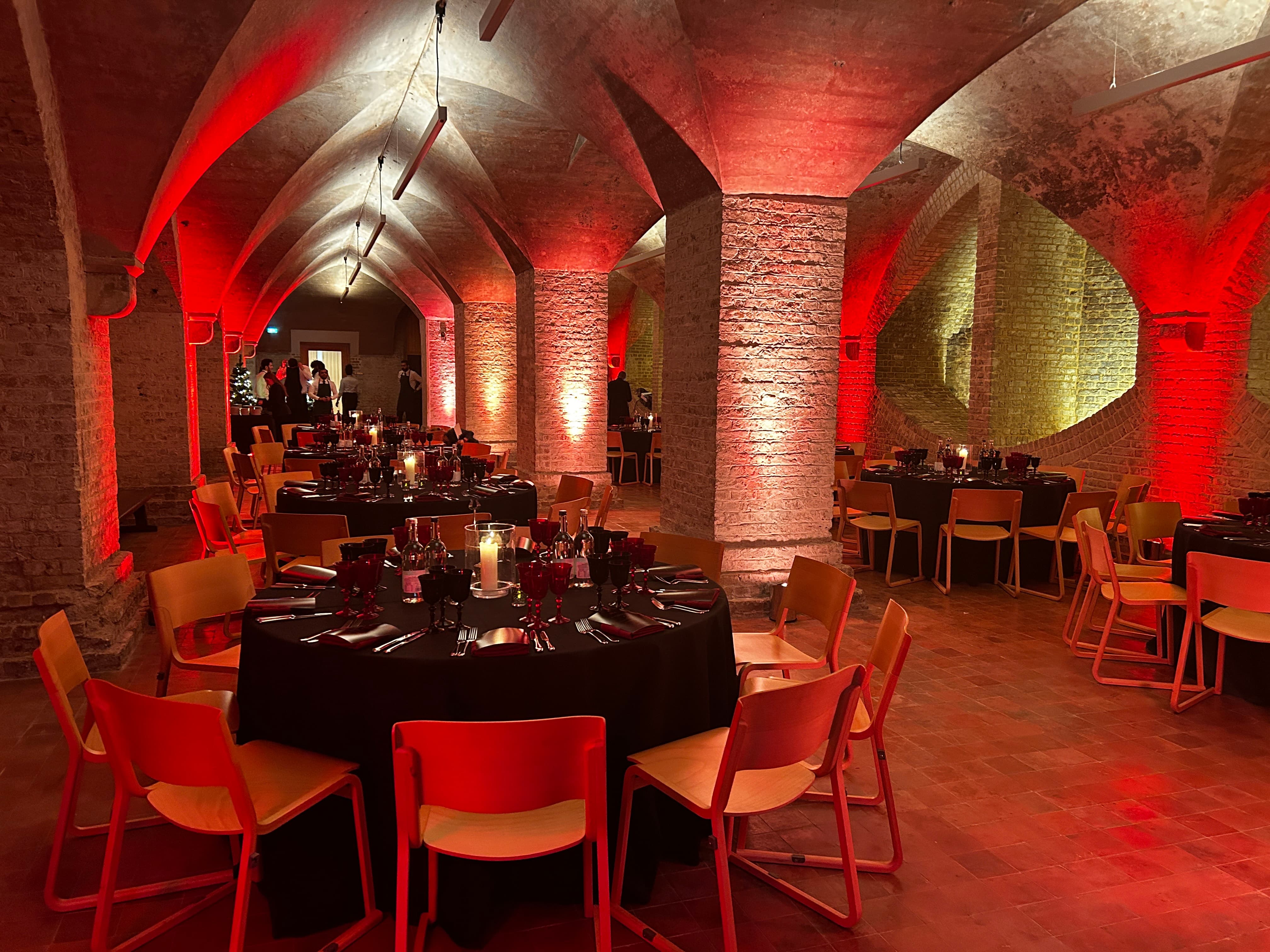 Elegant event space with round tables and warm lighting, perfect for gala or corporate dinner.