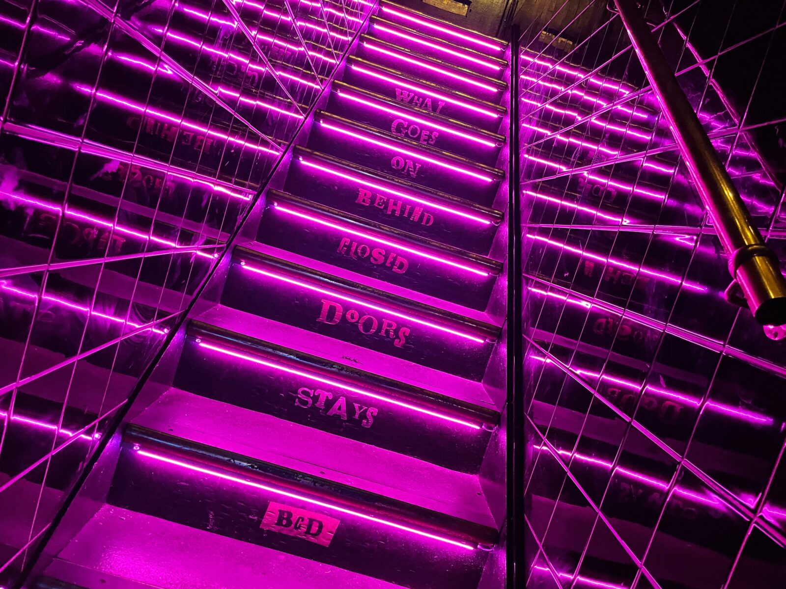 Neon-lit experiential stairwell at Behind Closed Doors, perfect for nightlife pop-up events.