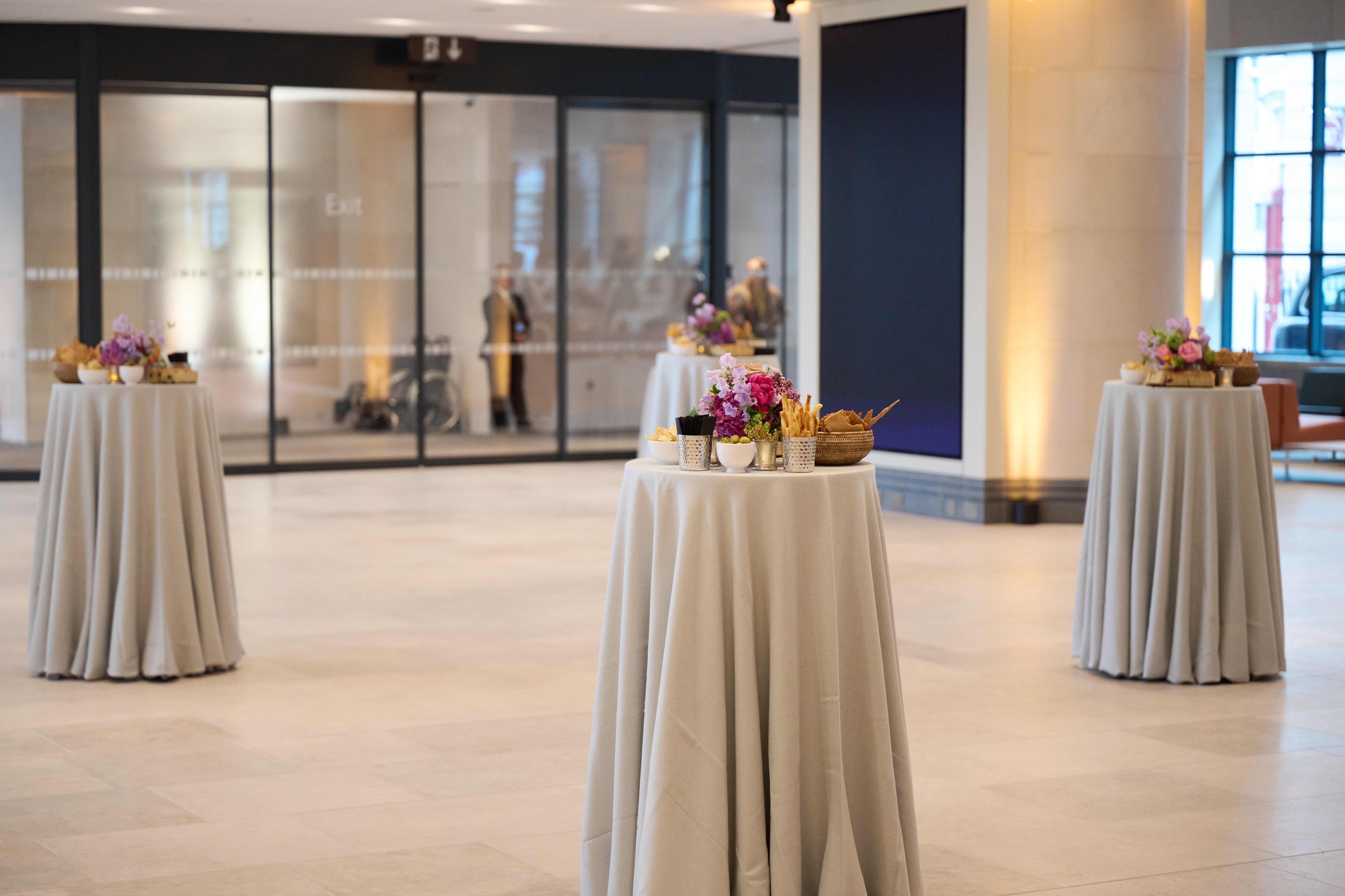 Sainsbury Wing Foyer, elegant event space with floral tables, perfect for receptions and networking.