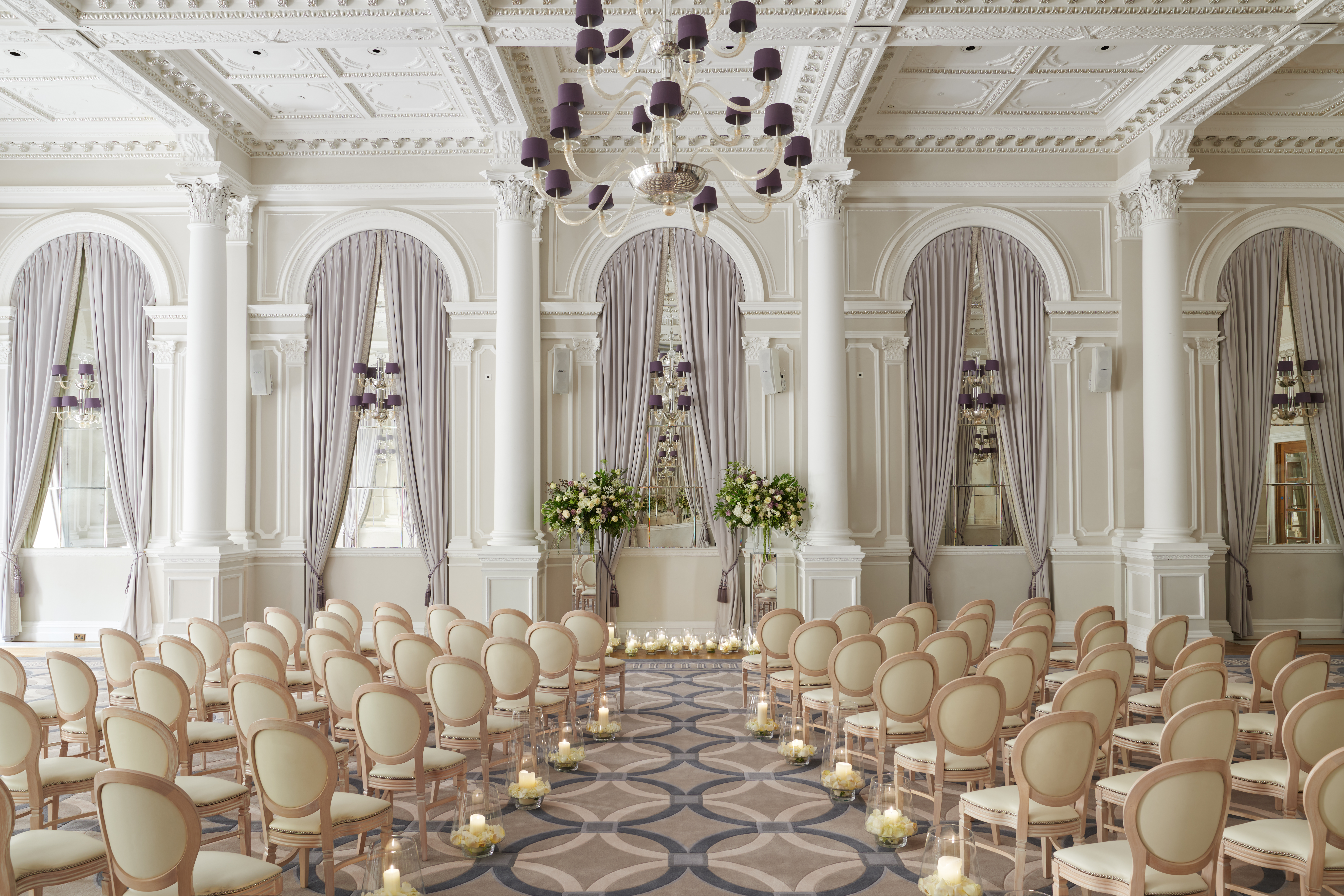 Elegant wedding venue at Corinthia London with high ceilings and floral arrangements.
