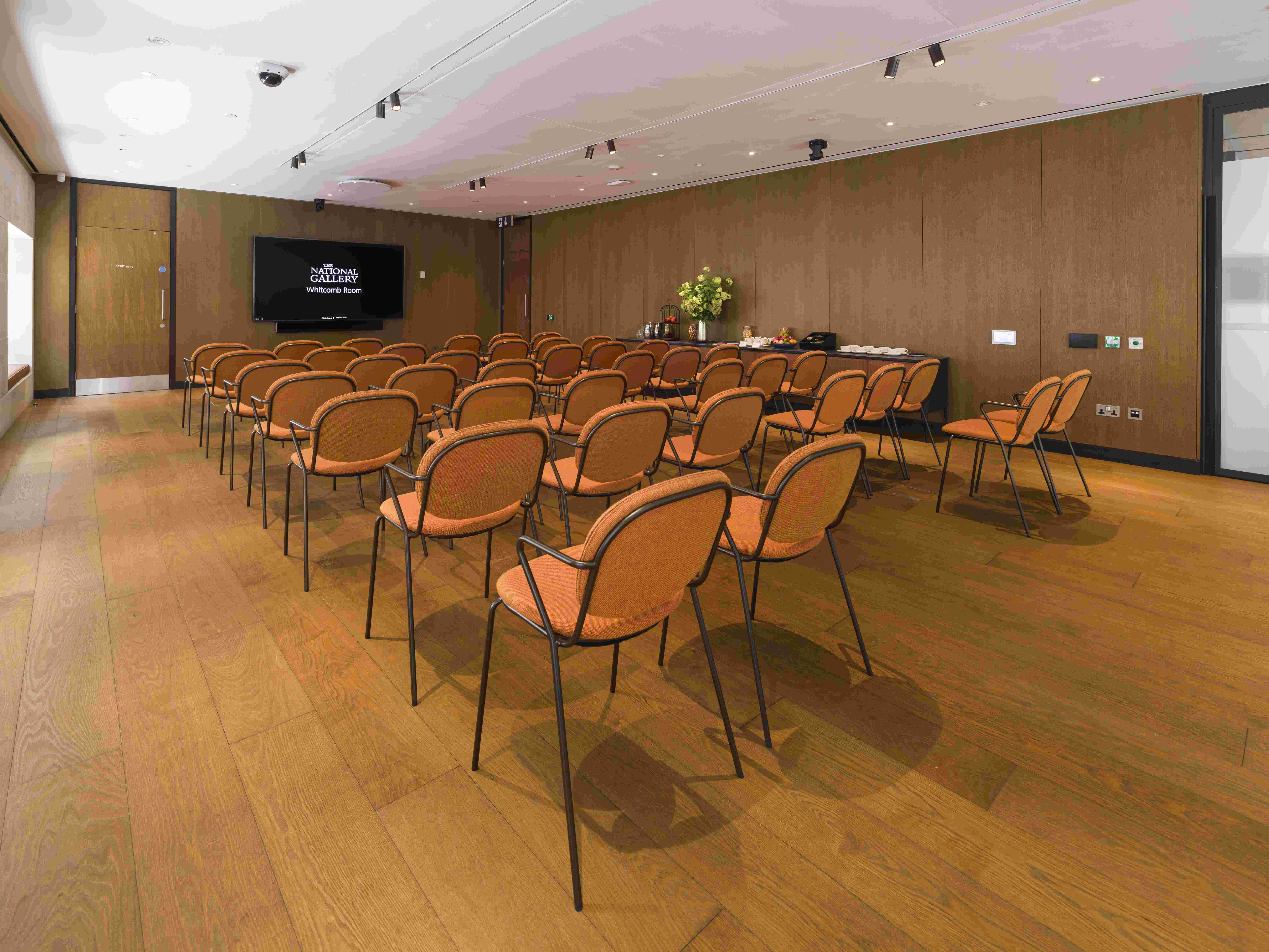 Whitcomb Meeting Room with orange chairs, perfect for corporate events and workshops.