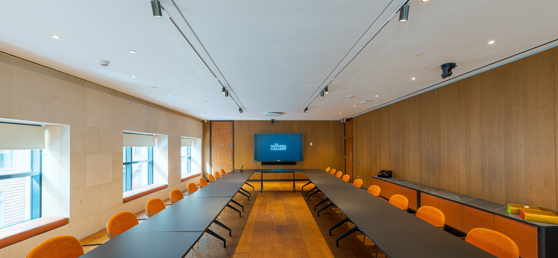 Whitcomb Meeting Room at The National Gallery, featuring ergonomic orange chairs for conferences.