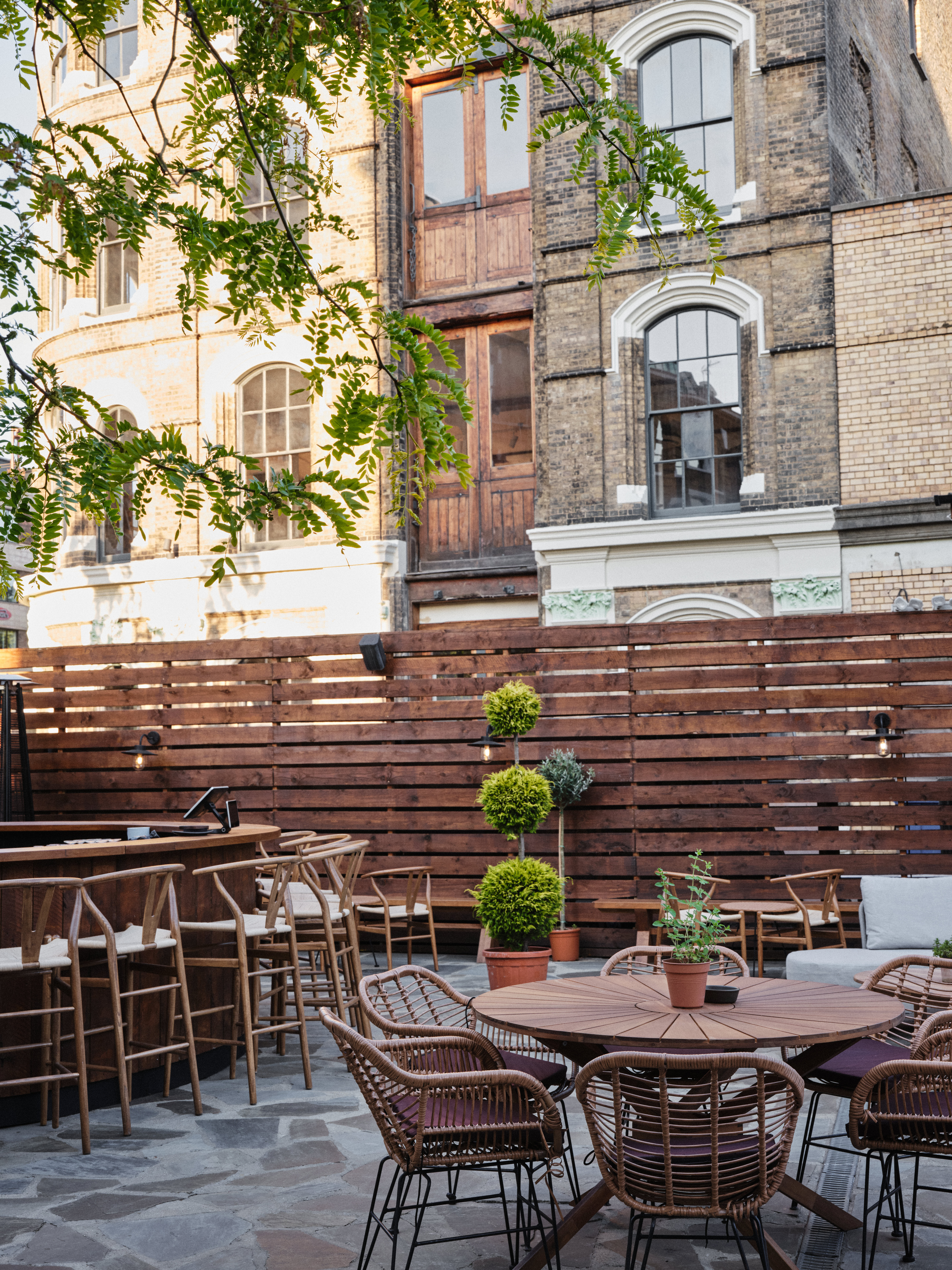 Outdoor event space at Pyro Terrace & Garden Bar with natural wood and greenery, perfect for gatherings.