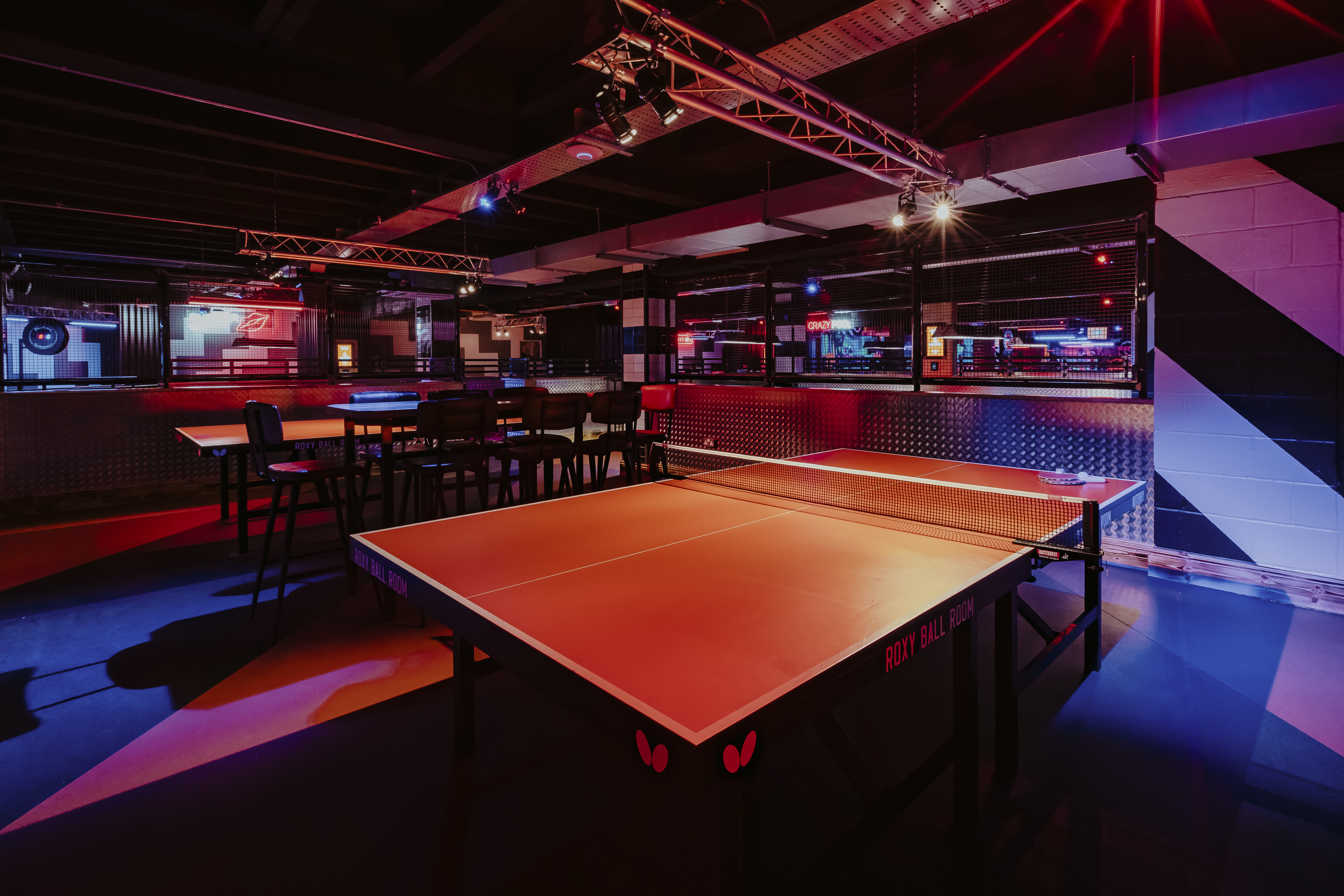 Vibrant Roxy Ball Room with ping pong tables, perfect for corporate events and social mixers.