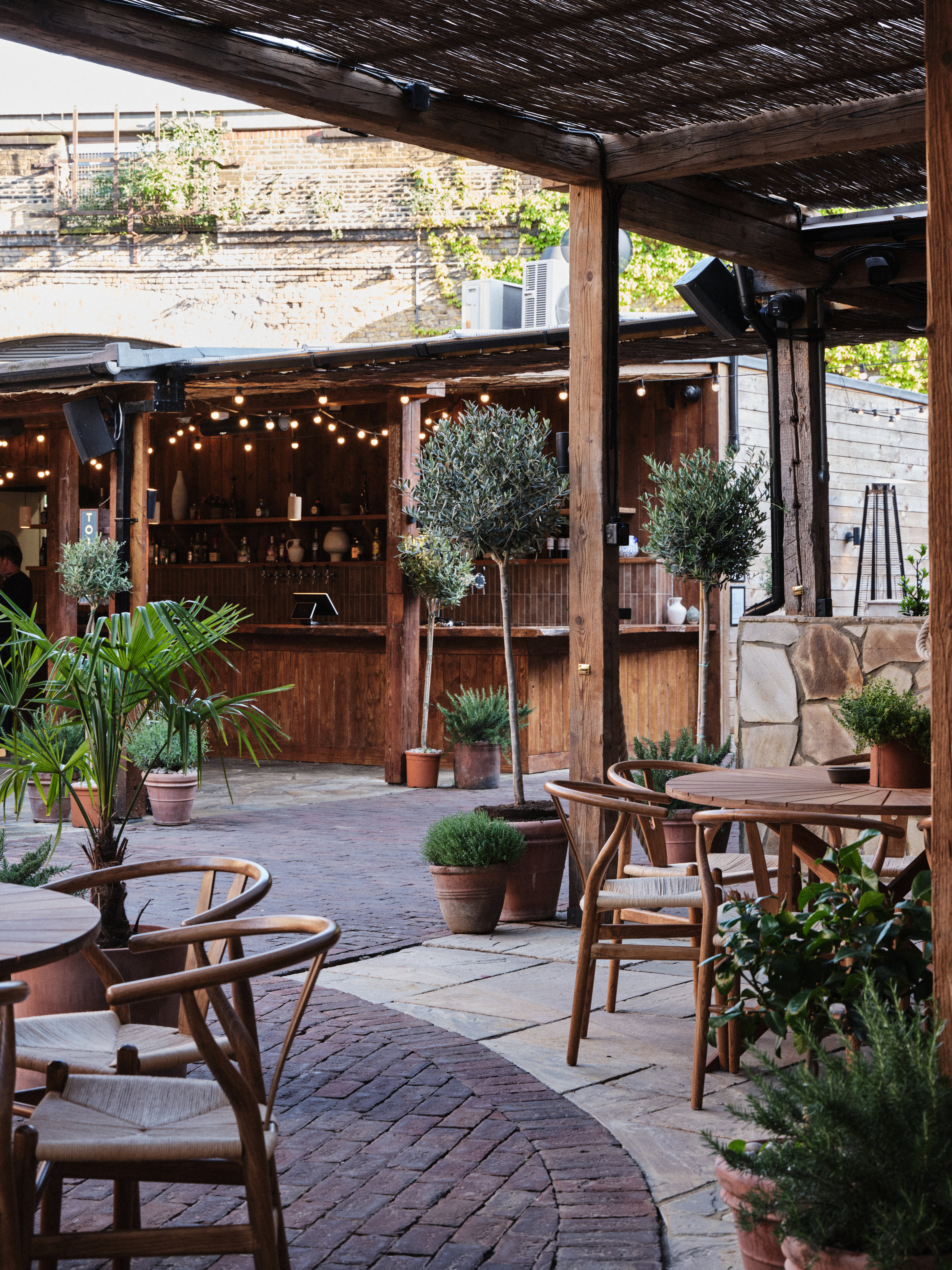 "Charming outdoor venue with warm lighting, ideal for cocktail receptions and networking."