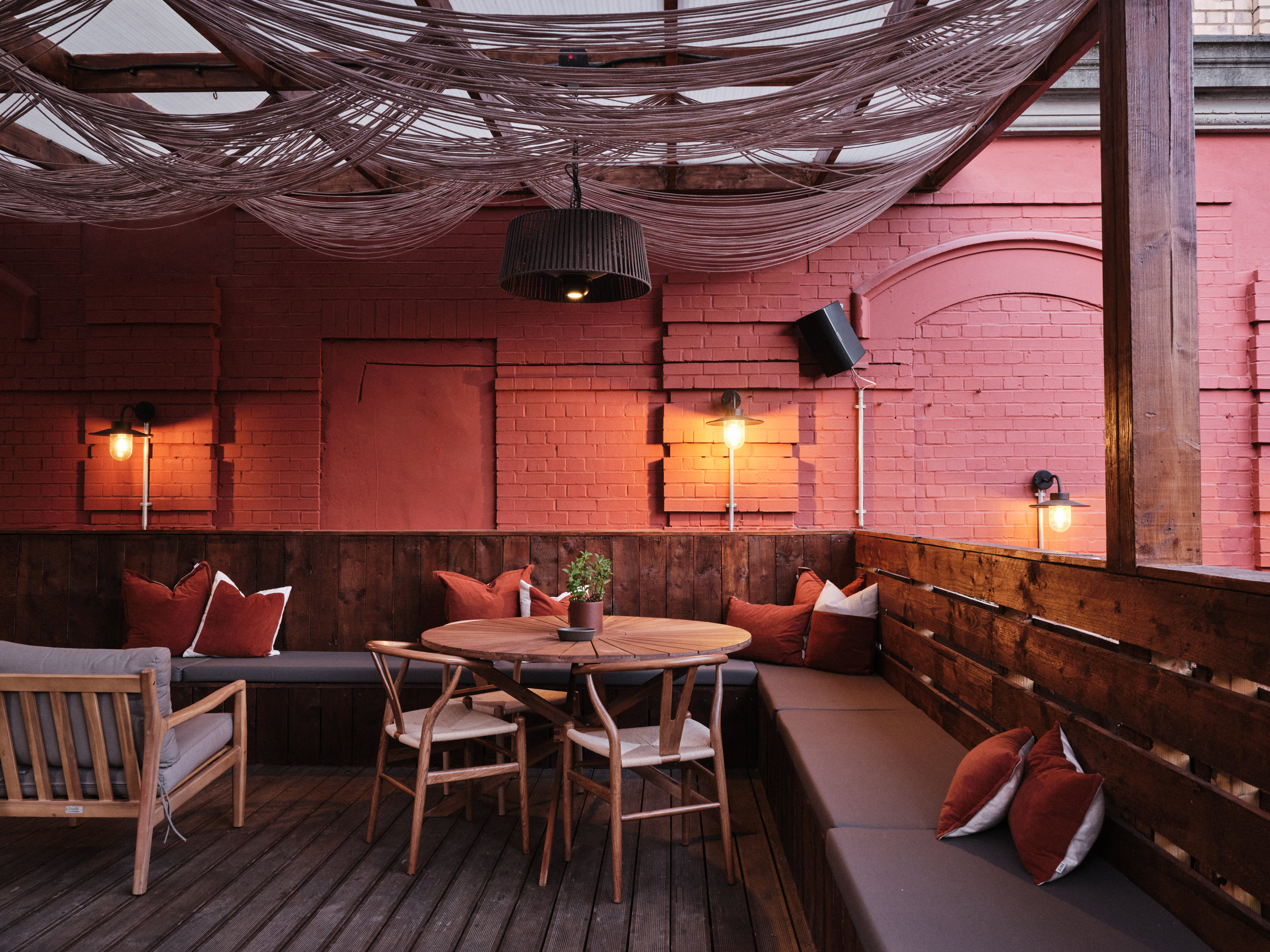 Outdoor meeting space with wooden table and cozy seating for creative gatherings.