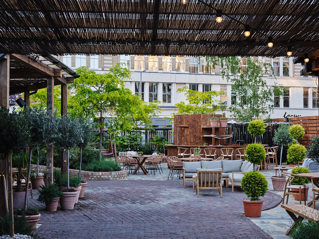 Charming outdoor venue with lush greenery, ideal for summer events and networking receptions.