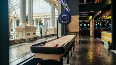 Sleek shuffleboard table at The Putt + Zone, perfect for team building events in Manchester.