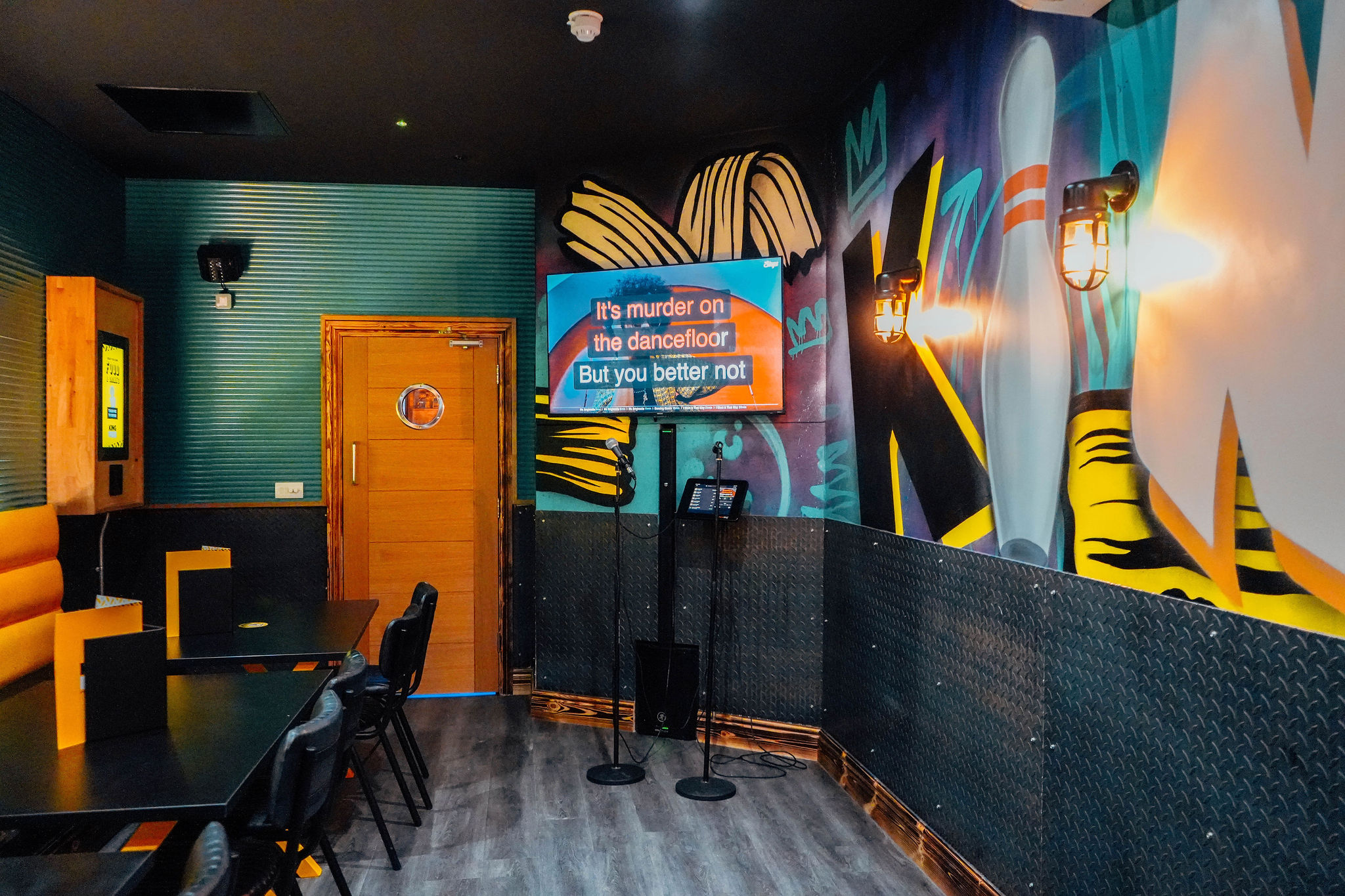 Vibrant Karaoke Room at King Pins, Manchester with colorful murals and modern decor.