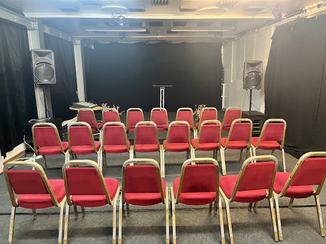 Premier Room 1 setup with red chairs for a professional presentation event.