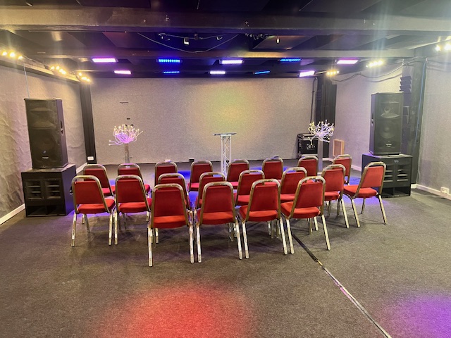 Premier Room 3 setup for presentations with red chairs, perfect for workshops and meetings.