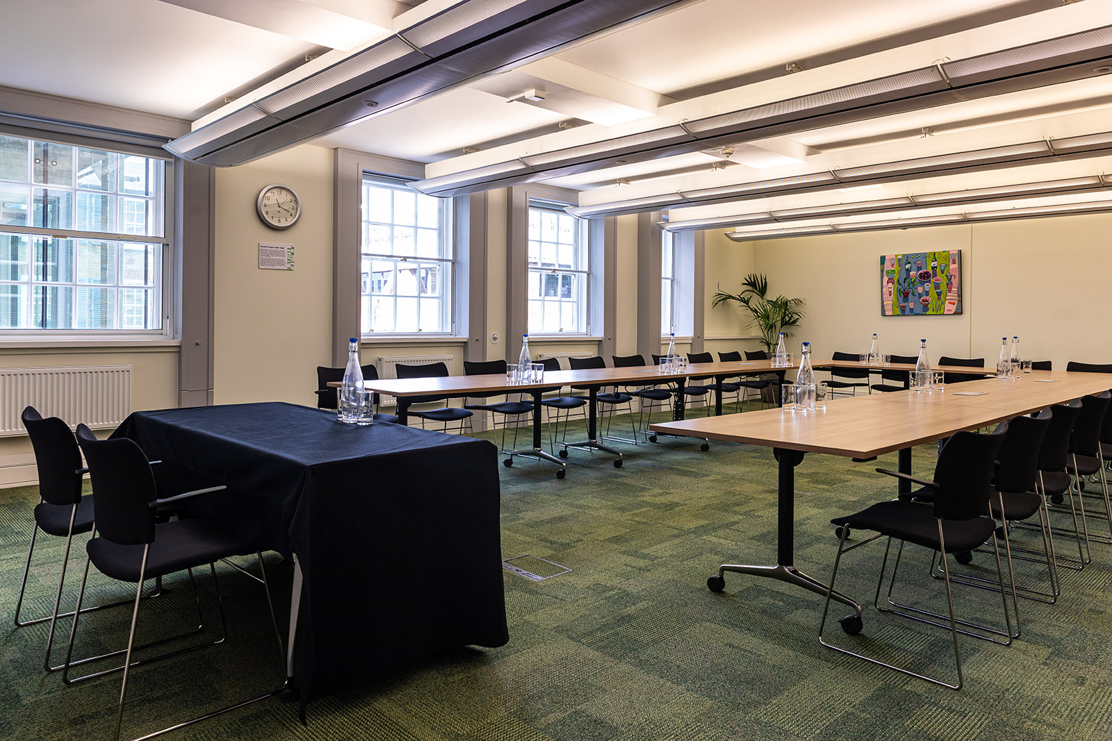 Rosalind Paget in a bright corporate meeting room with U-shaped table setup.