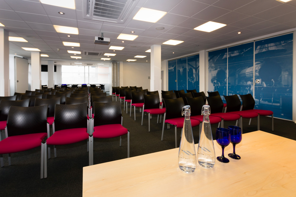 Mallard Suite conference room with black chairs and pink cushions, ideal for meetings and events.