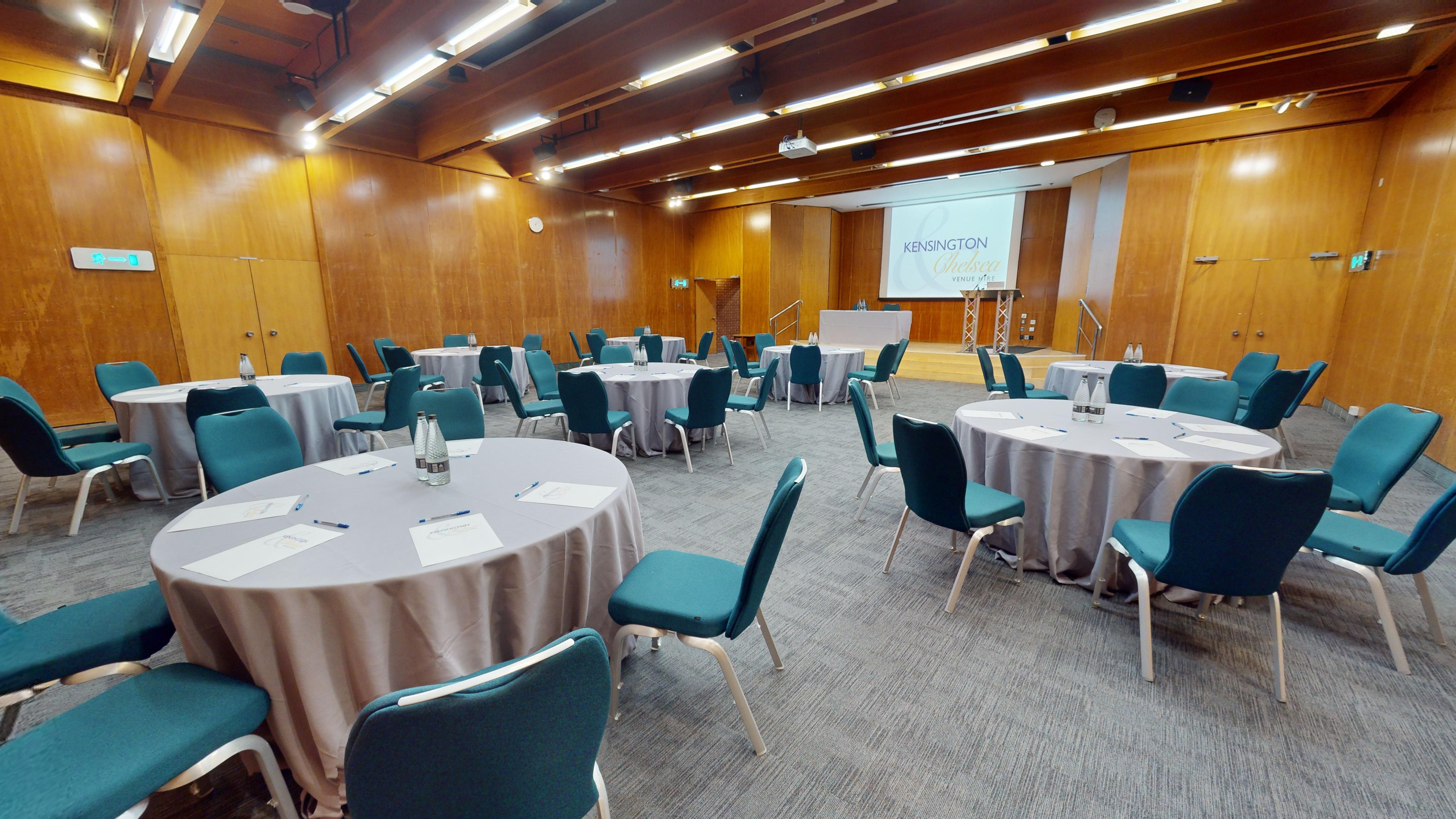 Small Hall at Kensington Centre, round tables set for a professional conference event.