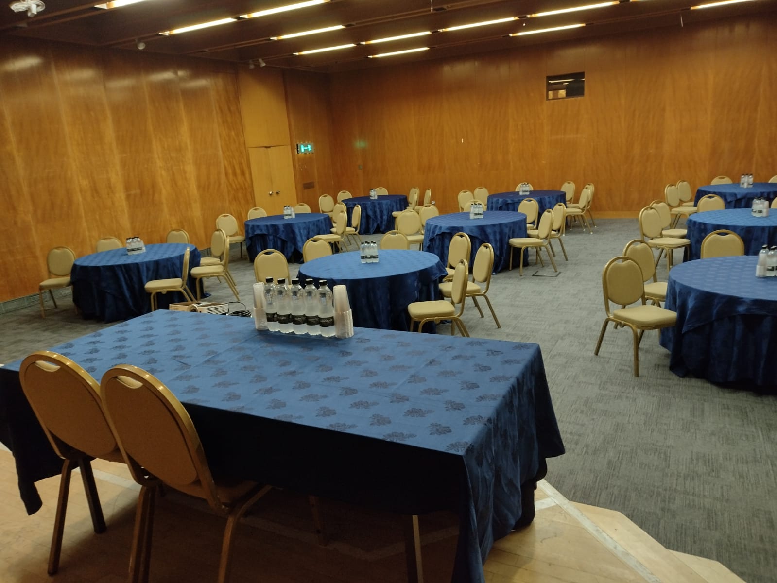 Small Hall at Kensington Conference Centre with round tables for meetings and events.