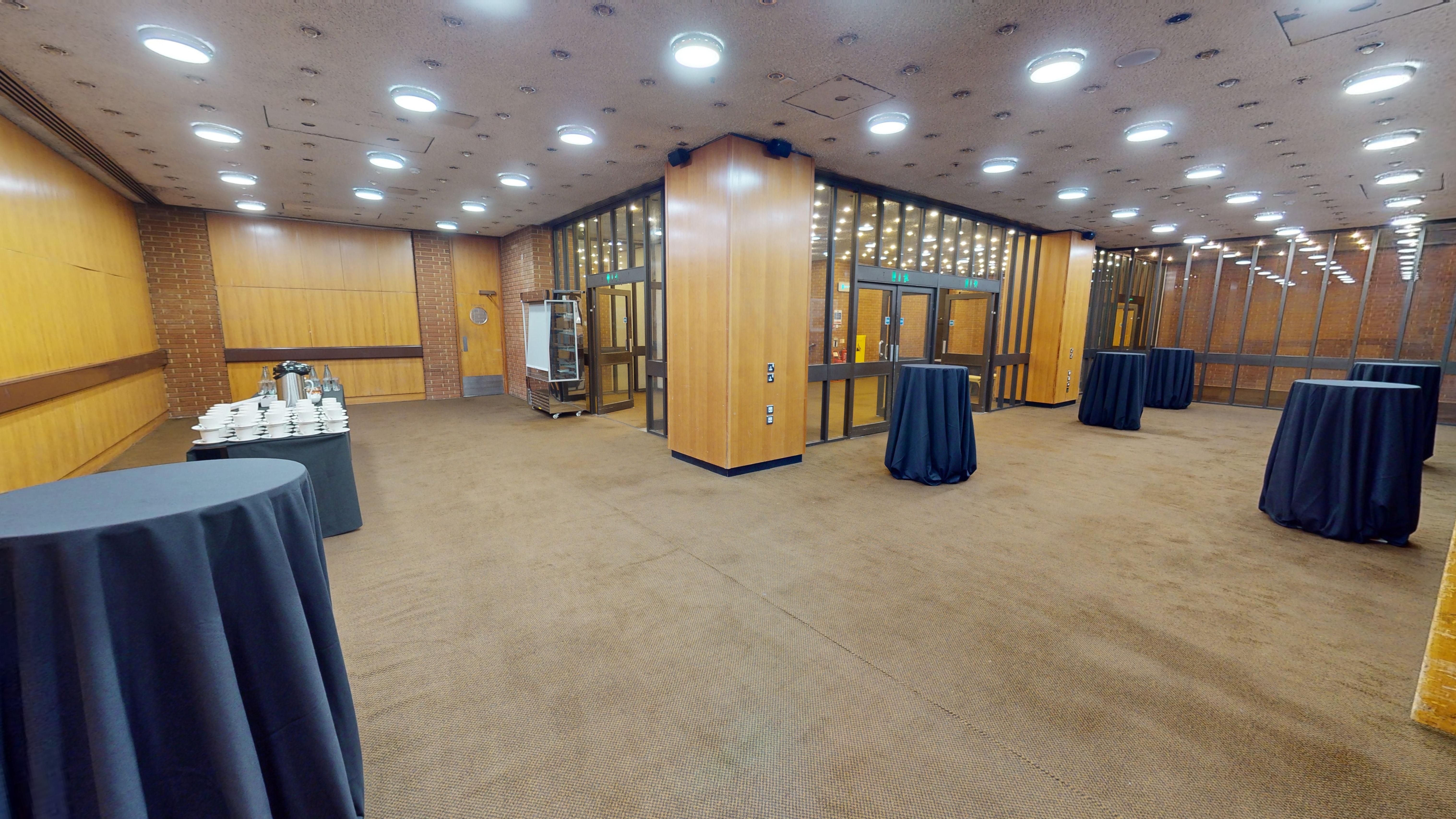 Spacious reception area with round tables, perfect for conferences and networking events.