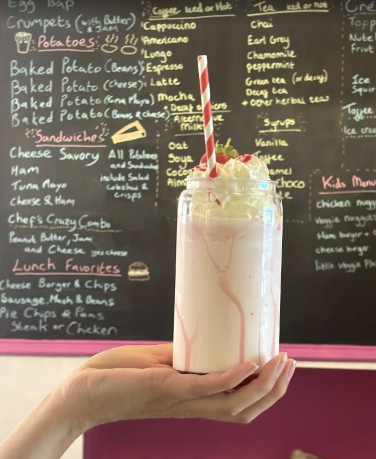 Vibrant milkshake with whipped cream at Canine Cuddle Cafe, perfect for events and gatherings.