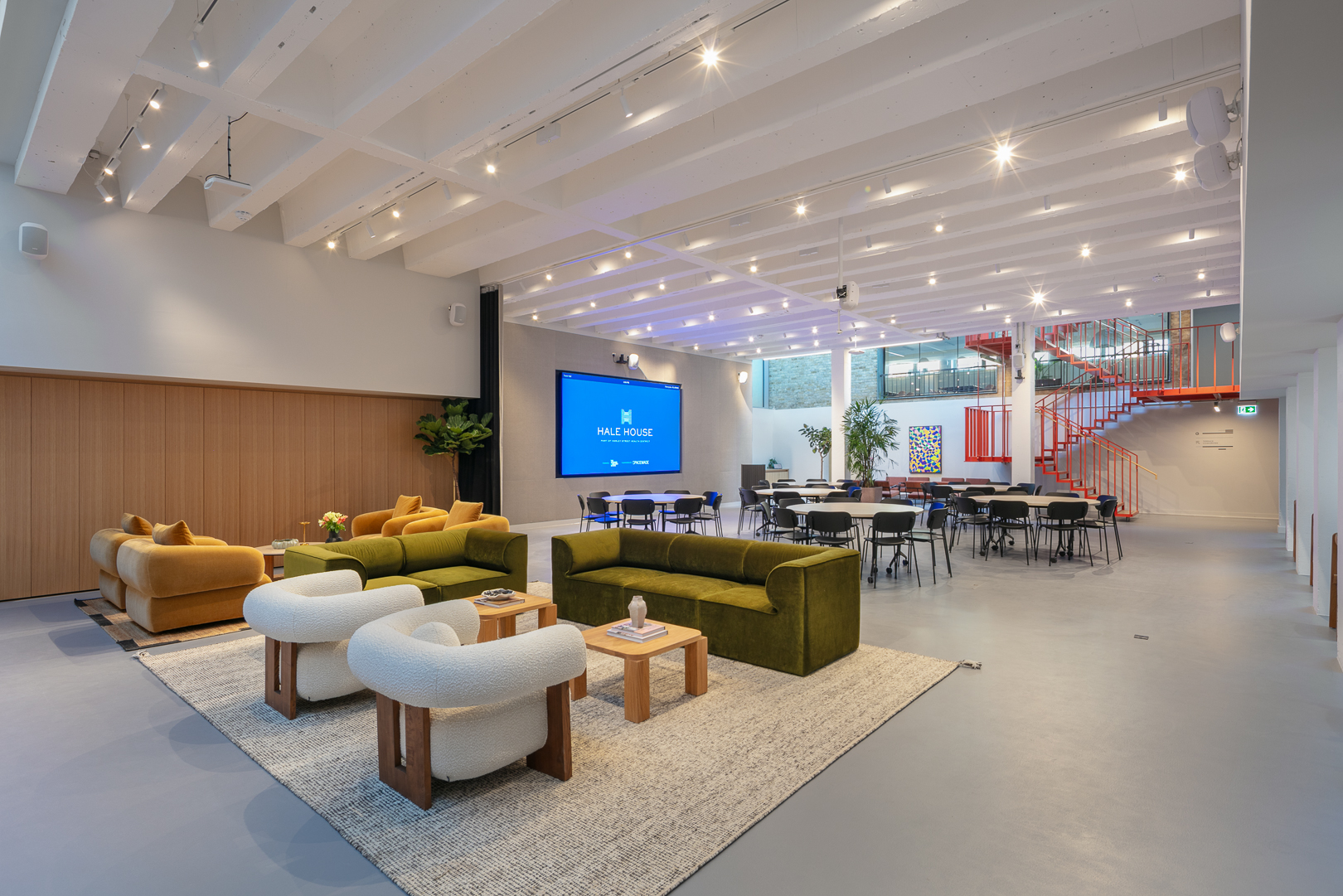 Corporate event lounge at Hale House with AV wall for networking and breakout sessions.