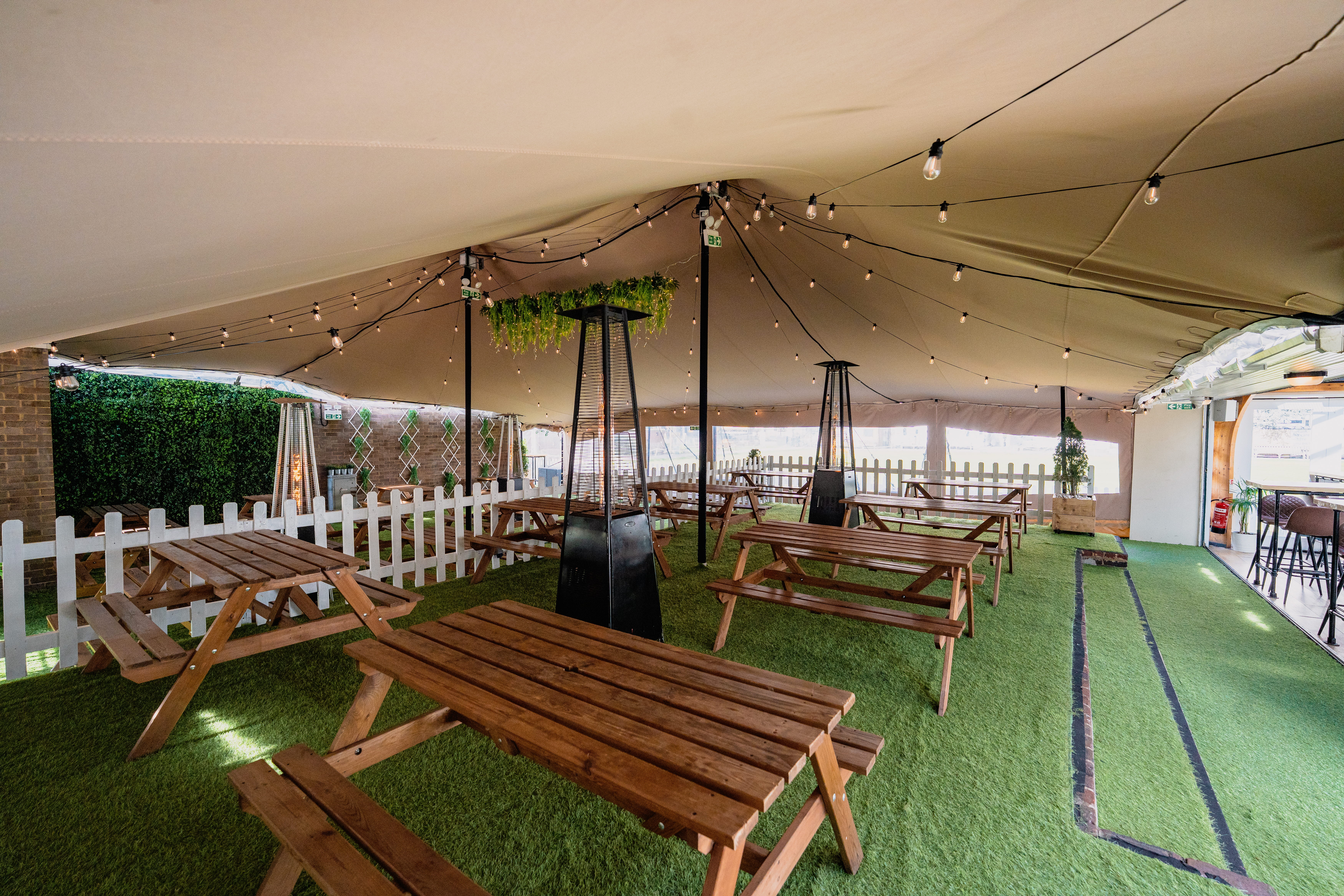 Outdoor event space at Finsbury Square with picnic tables and decorative lighting.