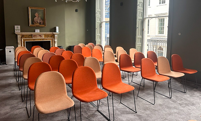 "Mary Brancker at British Veterinary Association meeting with modern orange chairs."