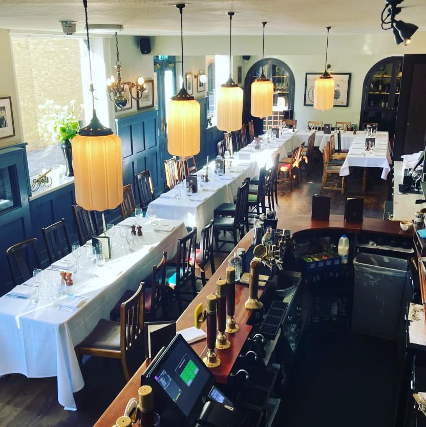 Dining room at The Gun with long tables, ideal for events and gatherings.