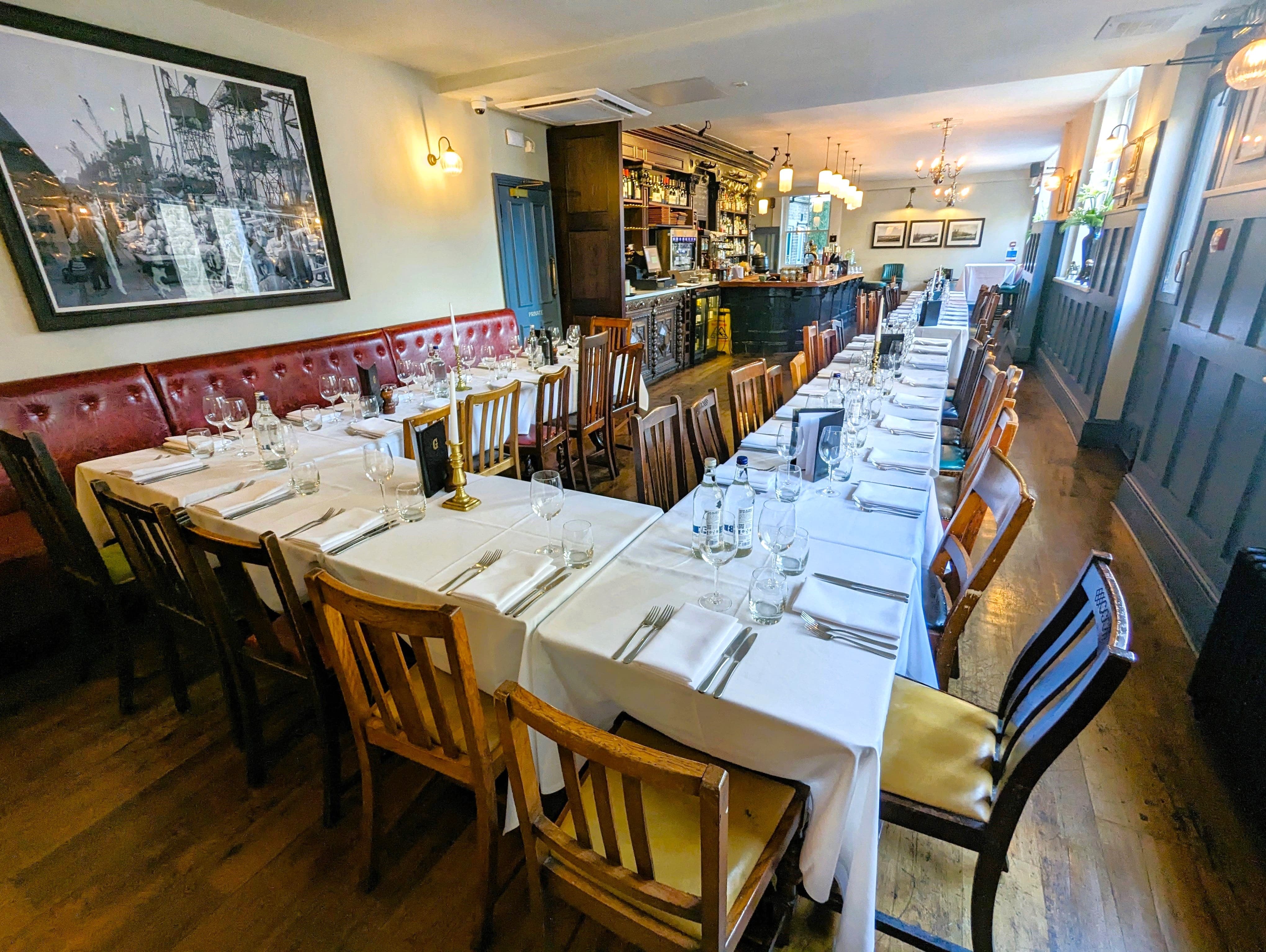 Elegant dining room for corporate events with long table and warm lighting.