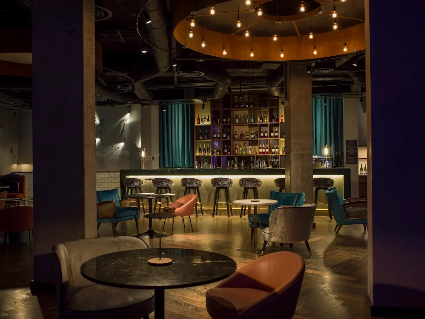 Stylish QT Basement Bar with warm lighting, perfect for networking events and meetings.