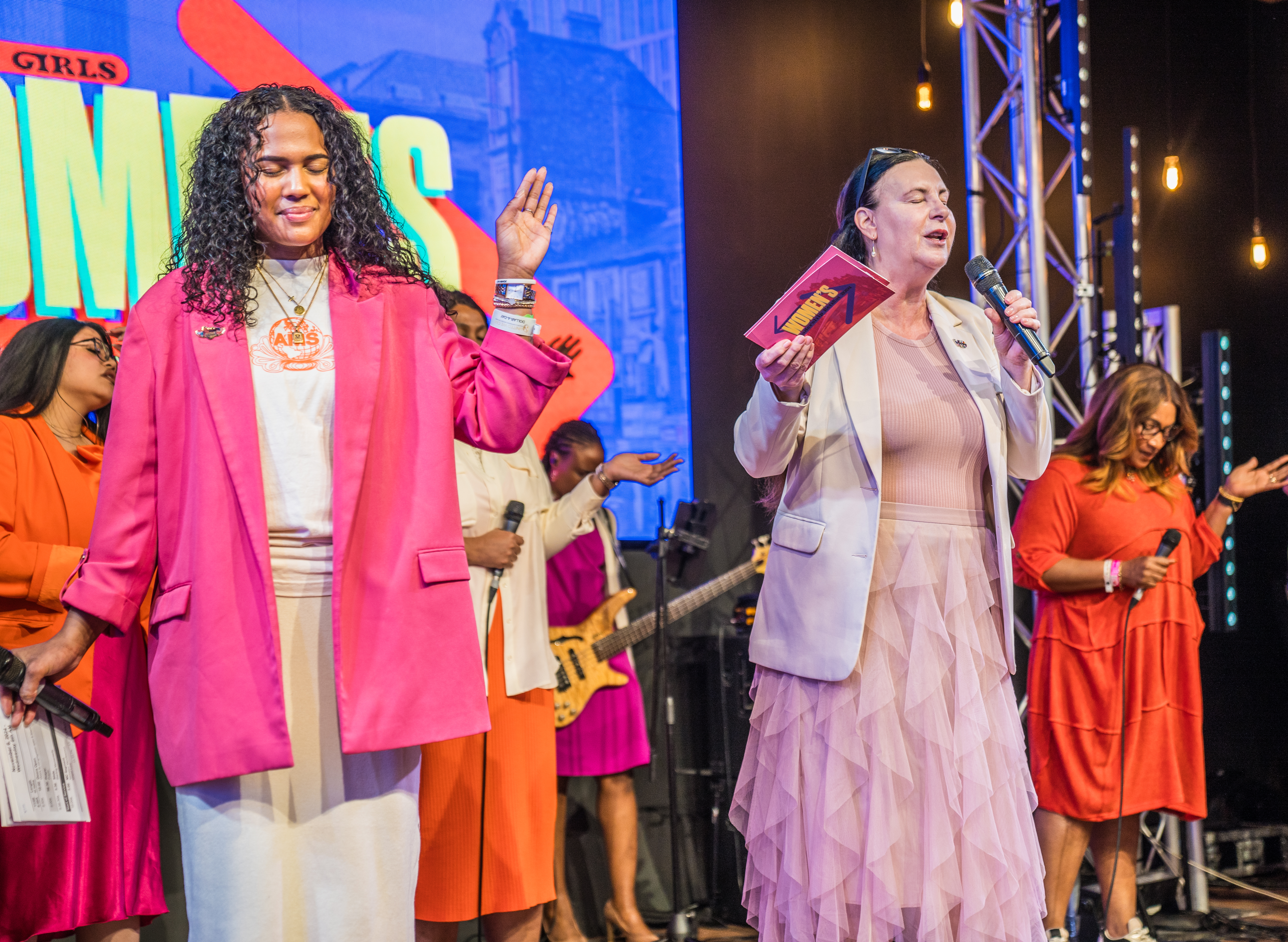 Large Function Hall stage with dynamic speakers at a vibrant motivational event.