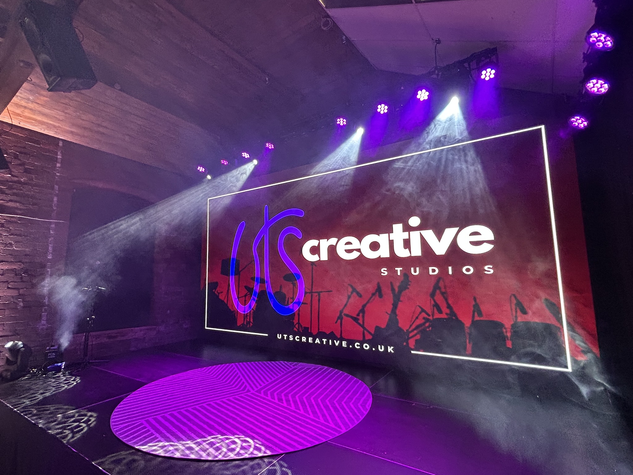 UTS Creative Studios LED wall stage with dramatic lighting for corporate events and live shows.