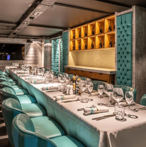 Teal tufted booths in Riva Blu Bullion Room, perfect for private dining and corporate events.