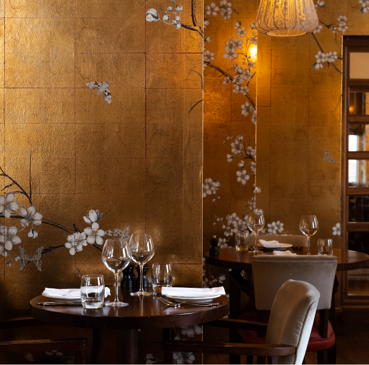 Private dining room with gold-leaf walls for executive boardroom dinners and VIP events.