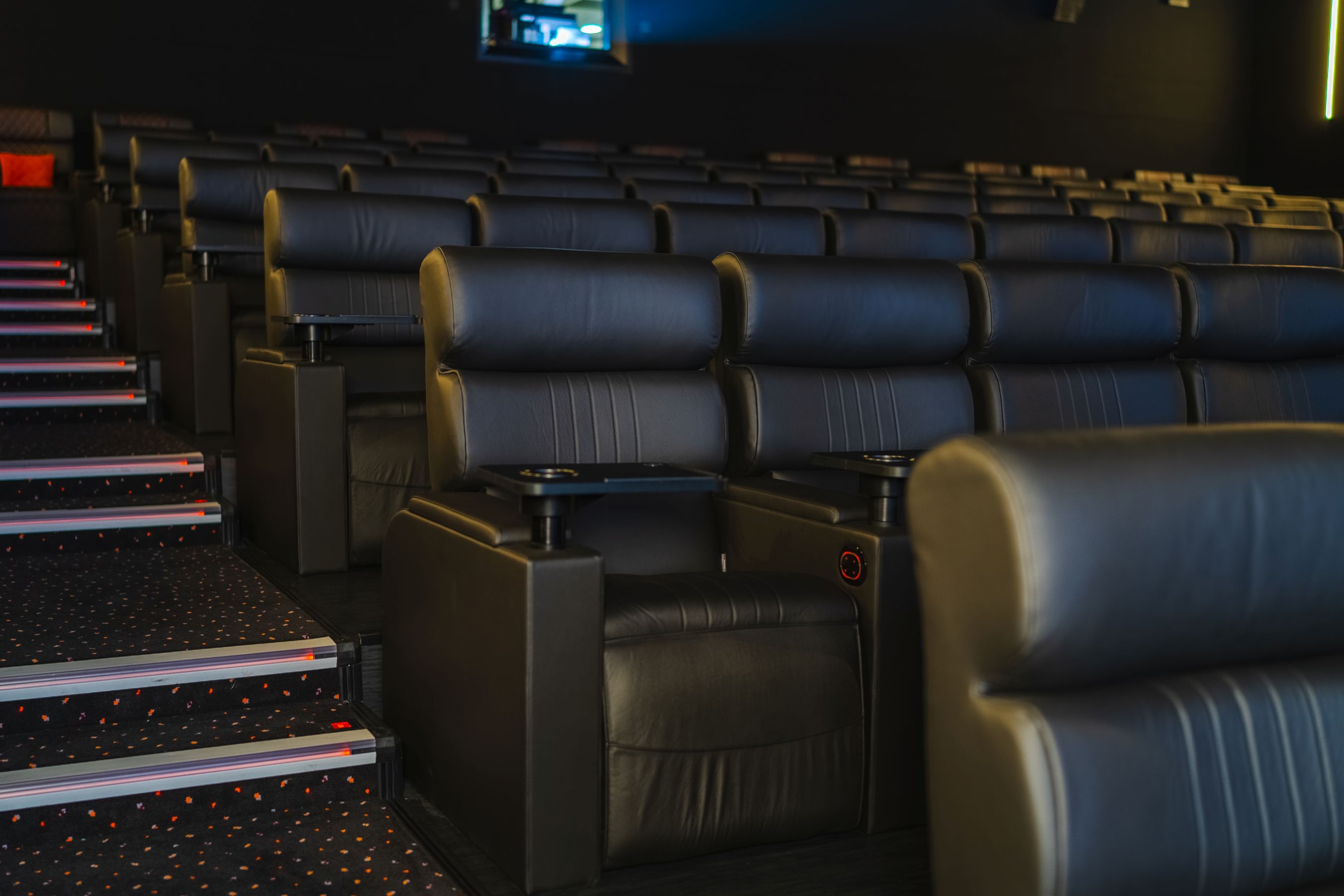 Luxury tiered cinema with leather reclining seats for corporate events and product reveals.