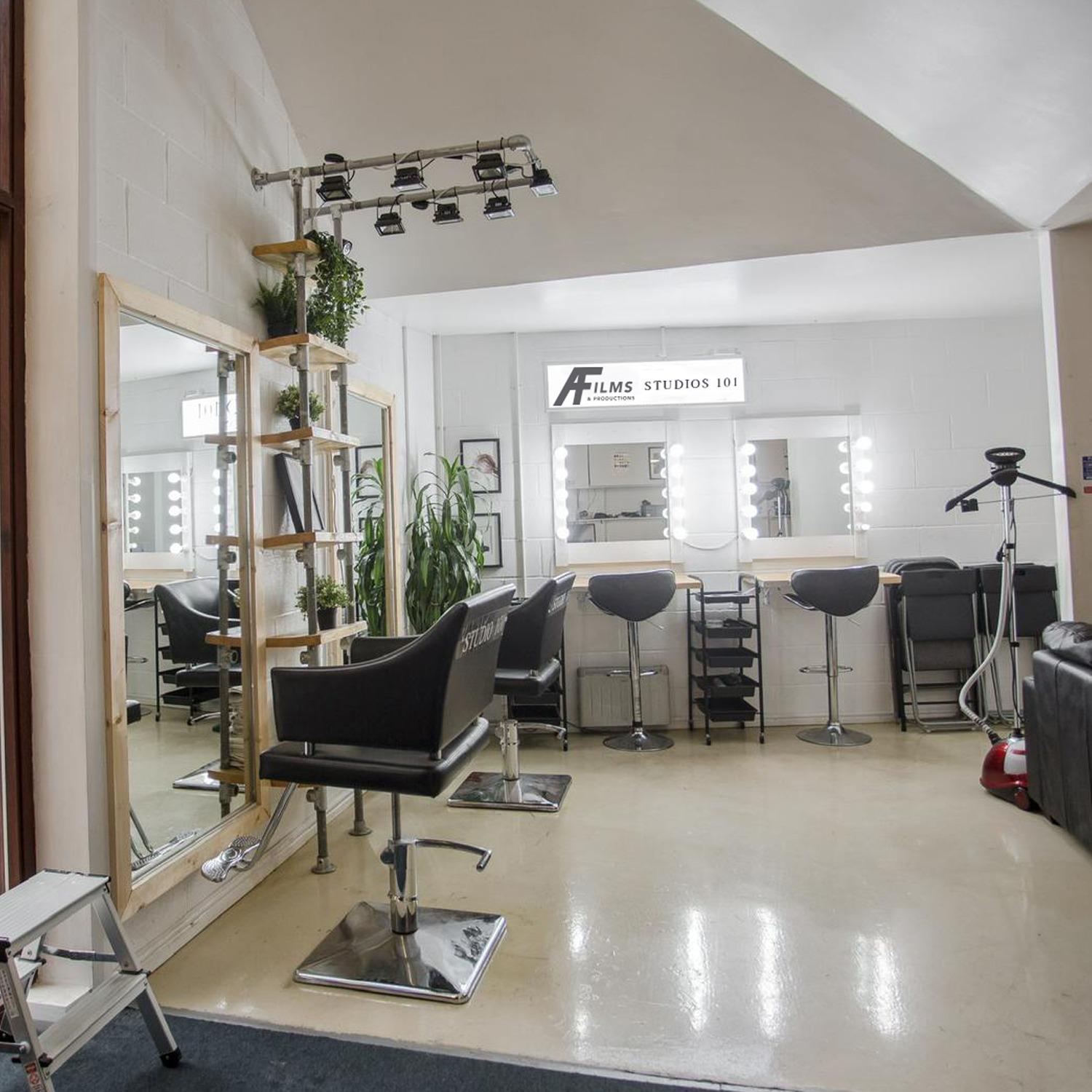 All-white makeup studio with mirrors and lighting for pre-event preparation.