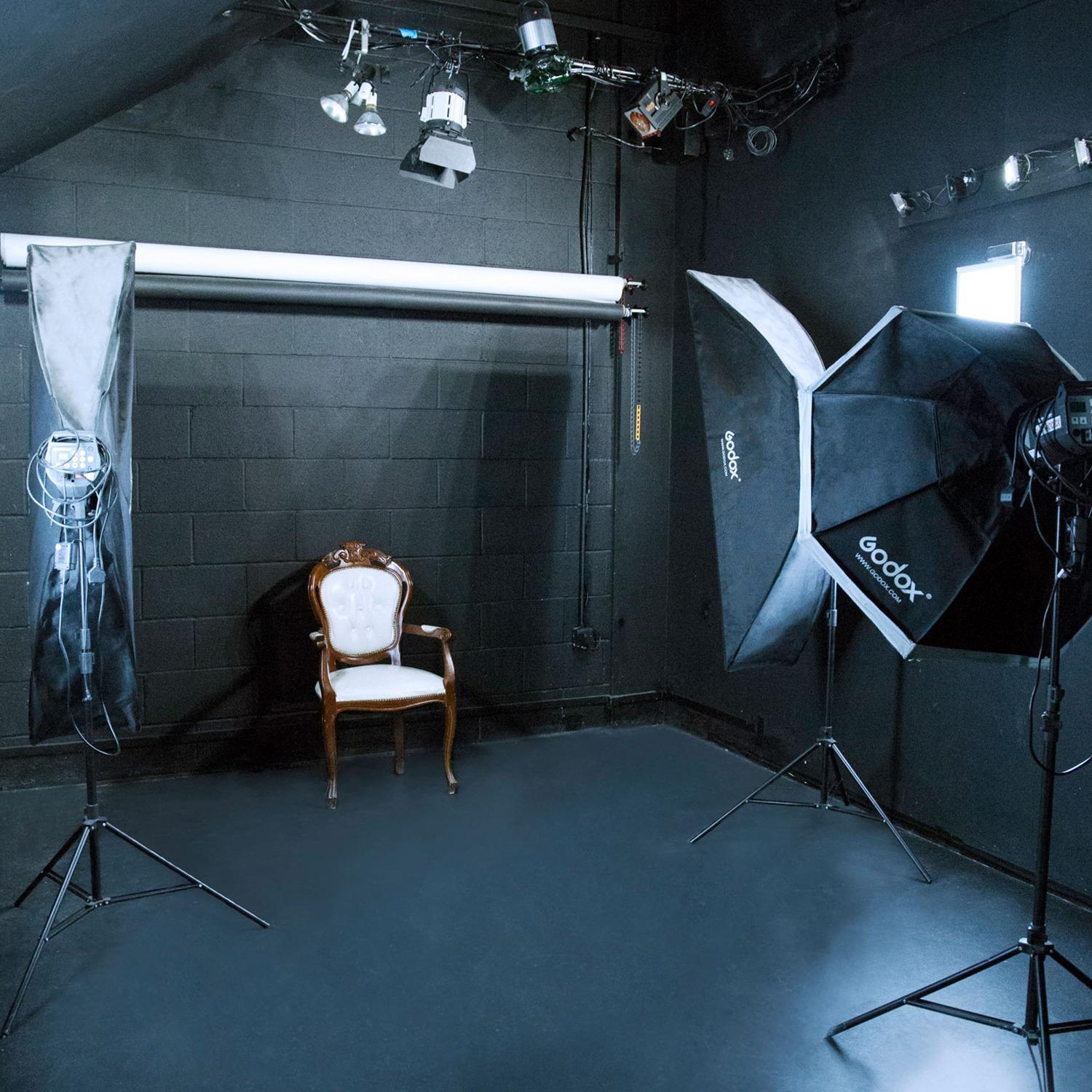 All-white photography studio with vintage chair, ideal for branding shoots and events.