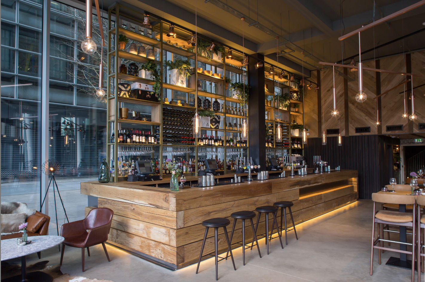 Modern bar with wooden counter in The Refinery, ideal for networking events and gatherings.