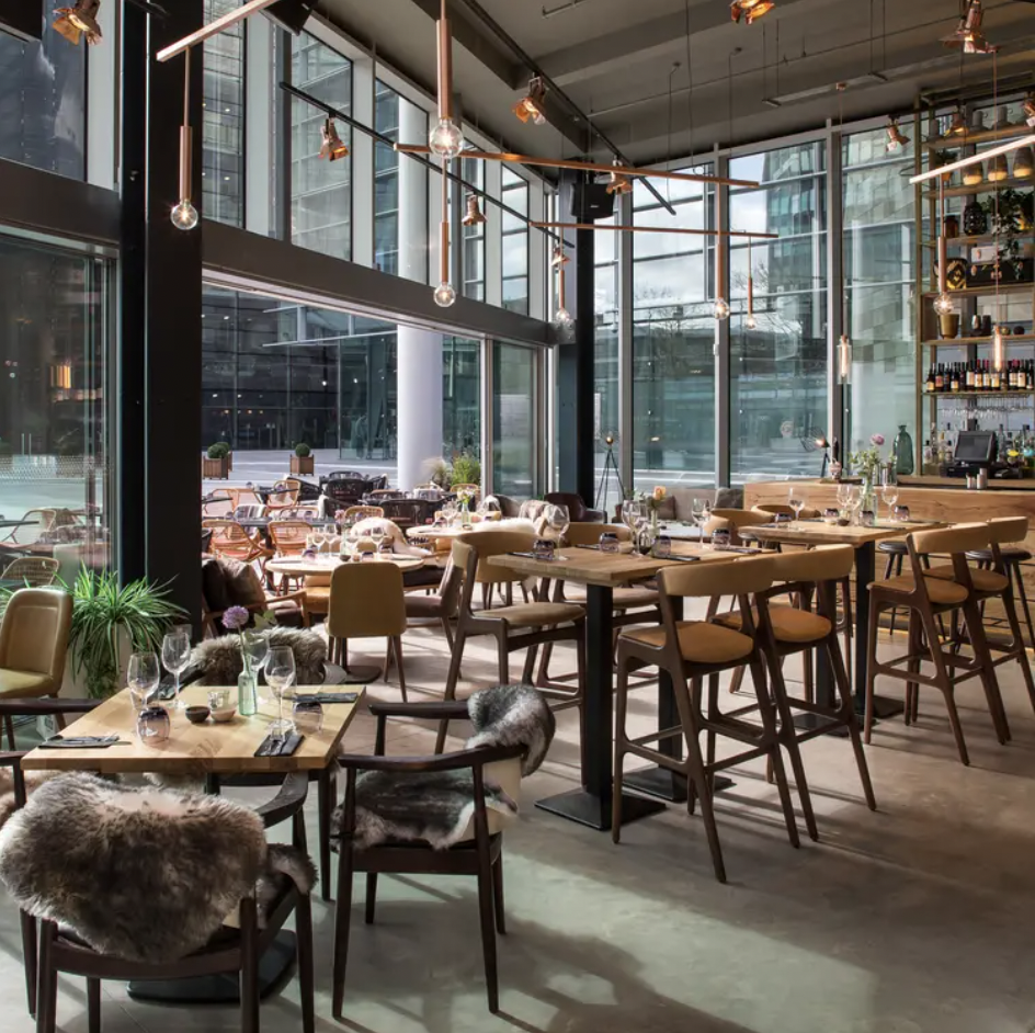 Modern restaurant interior with wooden tables, ideal for social gatherings and meetings.