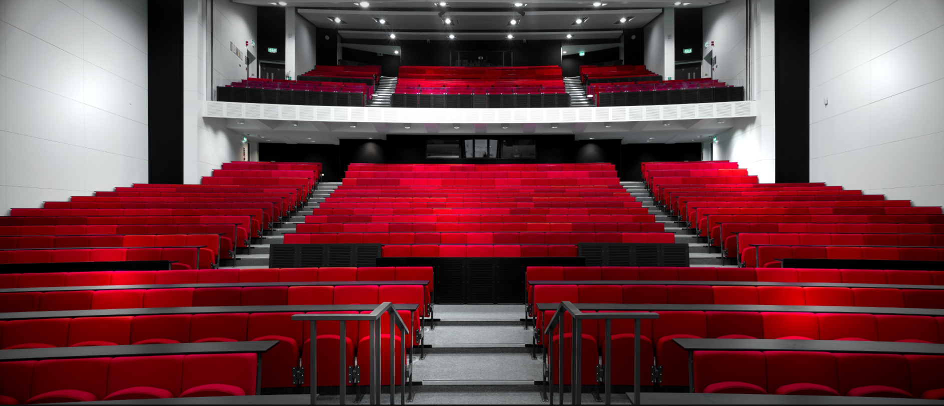 Modern auditorium at The University of Manchester with vibrant red seating for events.