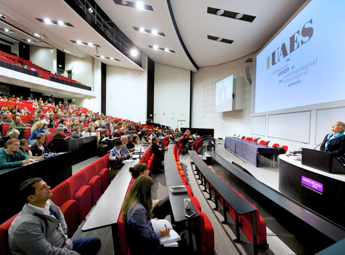 Engaged audience in tiered seating at a conference in University Place, Manchester.