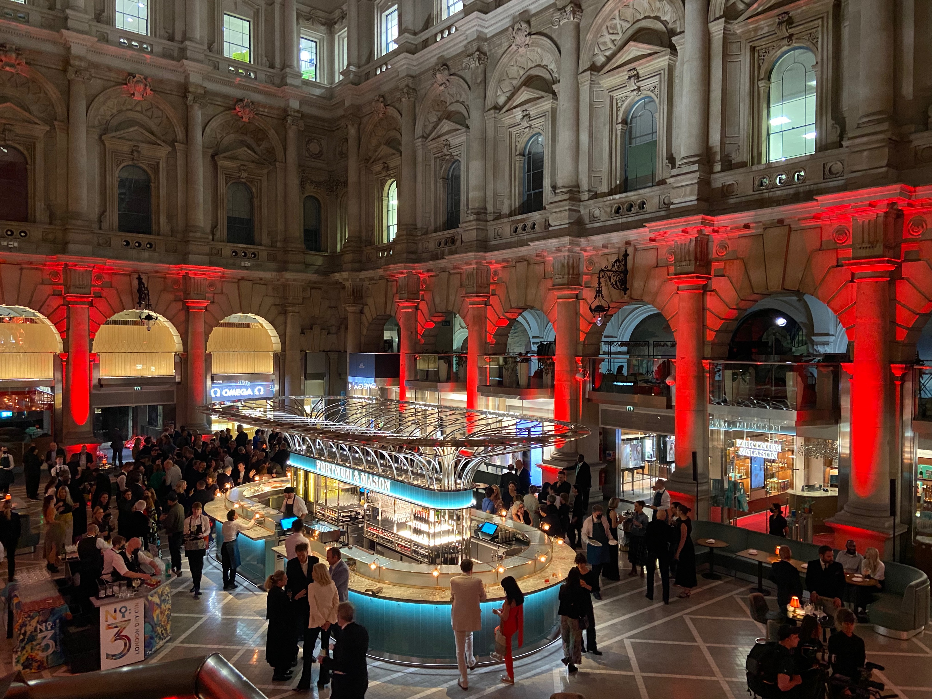 Vibrant networking event at Fortnum, Royal Exchange with stylish bar and red lighting.