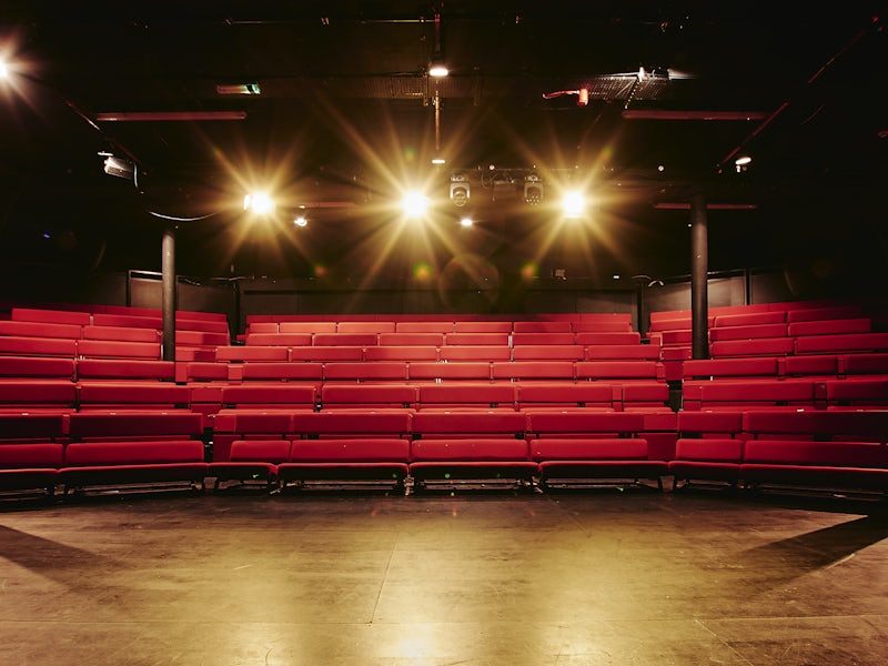 Factory Theatre black-box space with tiered bench seating for keynote presentations and panels.