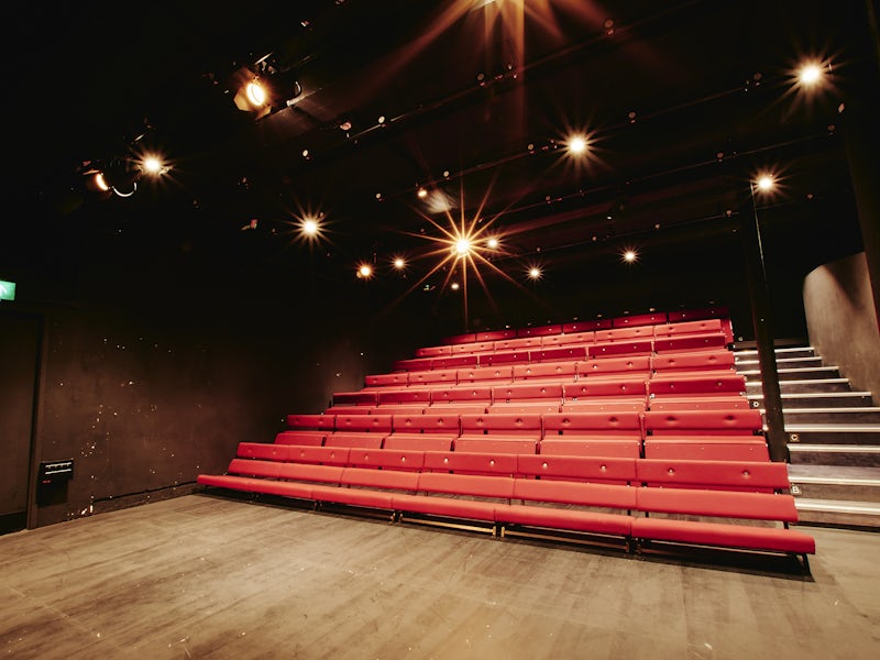 Spielman Theatre black-box with tiered bench seating for workshops and corporate keynotes.