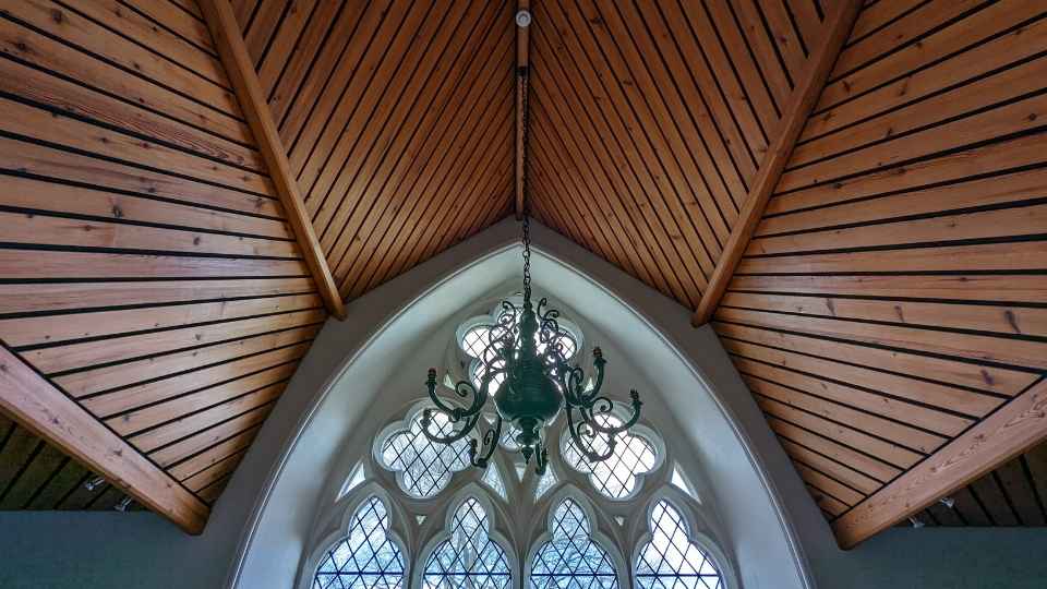 Elegant Boardroom with wooden beams and chandelier, ideal for upscale meetings and events.
