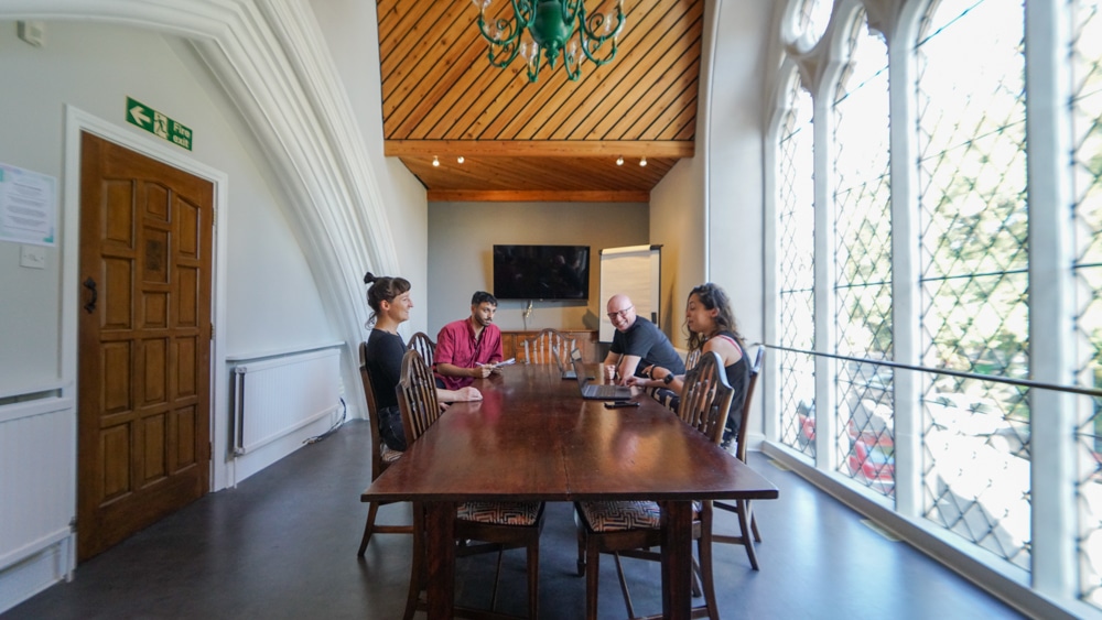 Bright meeting room with wooden table, ideal for brainstorming sessions and presentations.