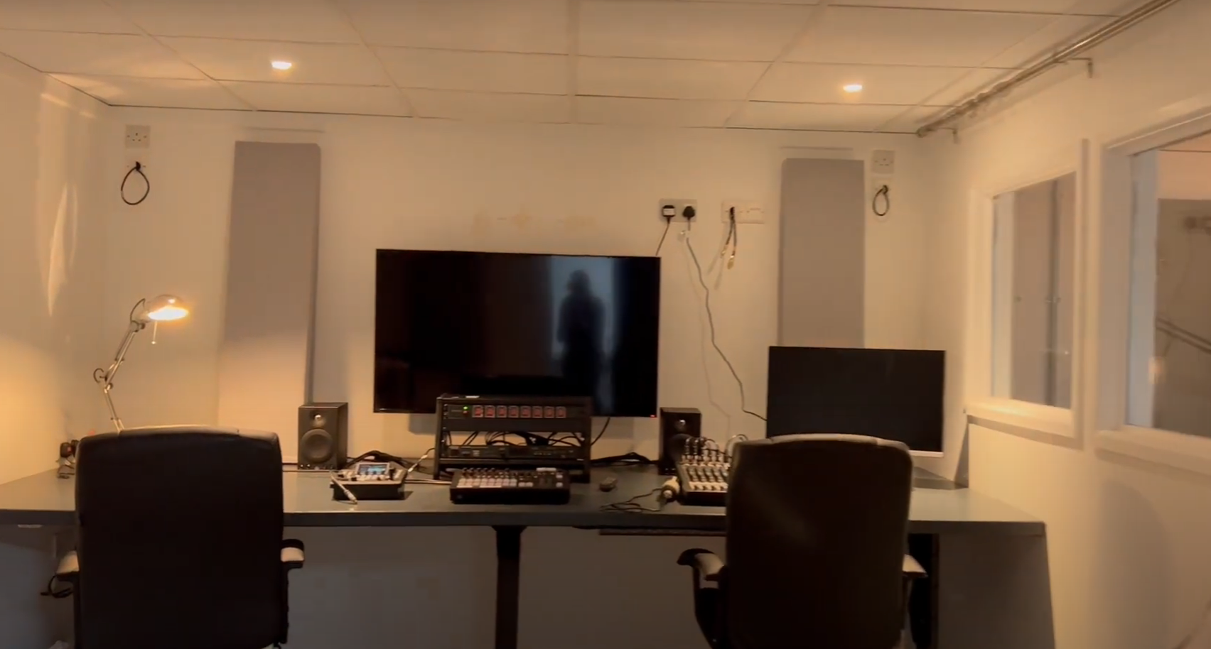 Modern podcast studio with advanced audio-visual setup for hybrid meetings and events.