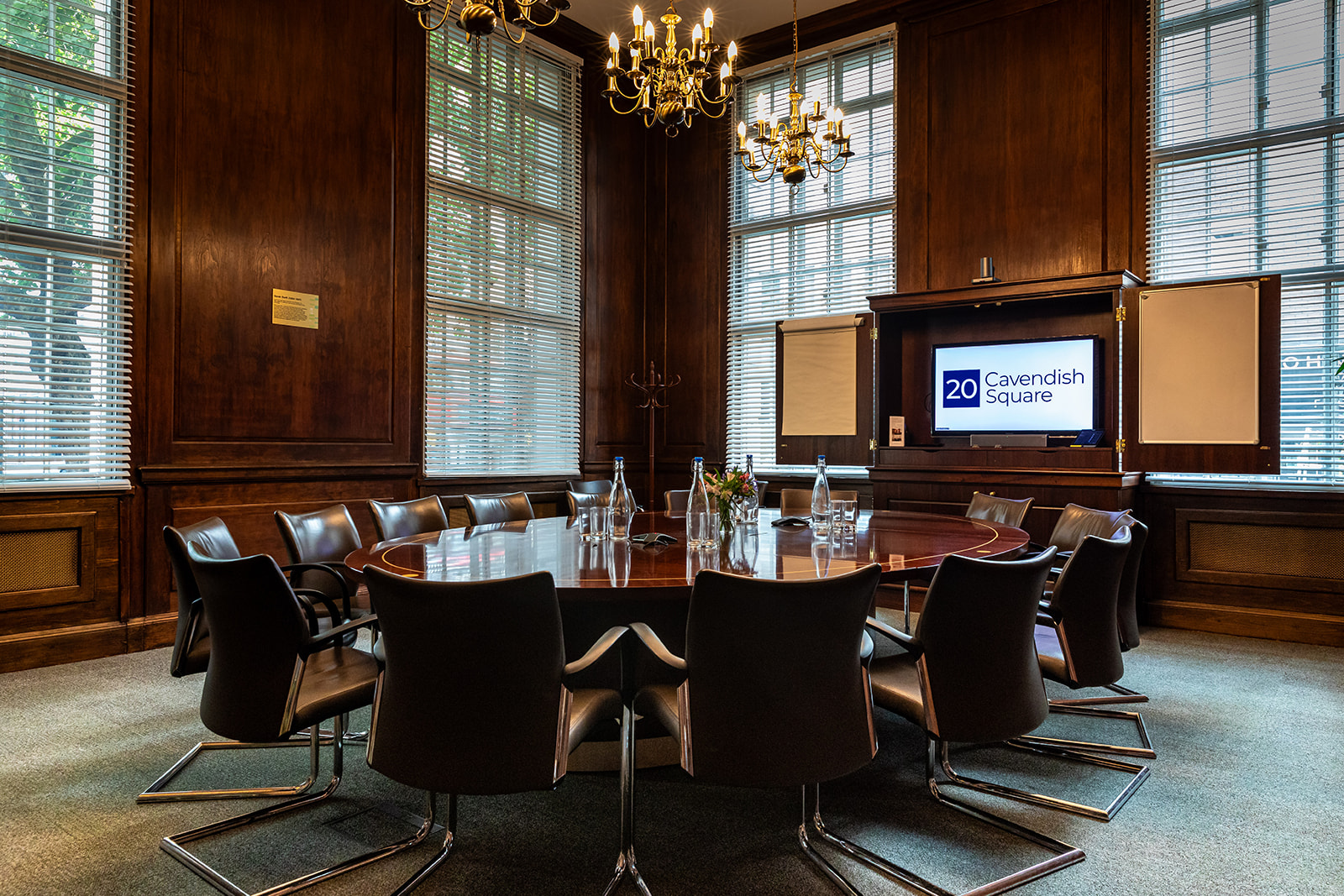 "Professional meeting room with Sarah Swift, round table, perfect for executive sessions"